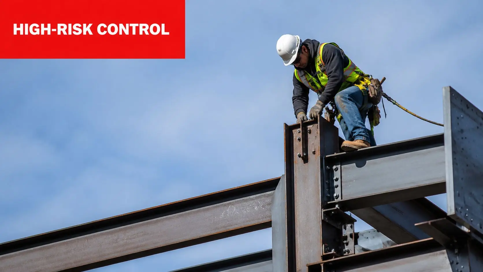 Construction Site Safety Rules and Regulations PDF Guide 2 A construction worker wearing safety gear and a harness installs structural steel beams at a high elevation.